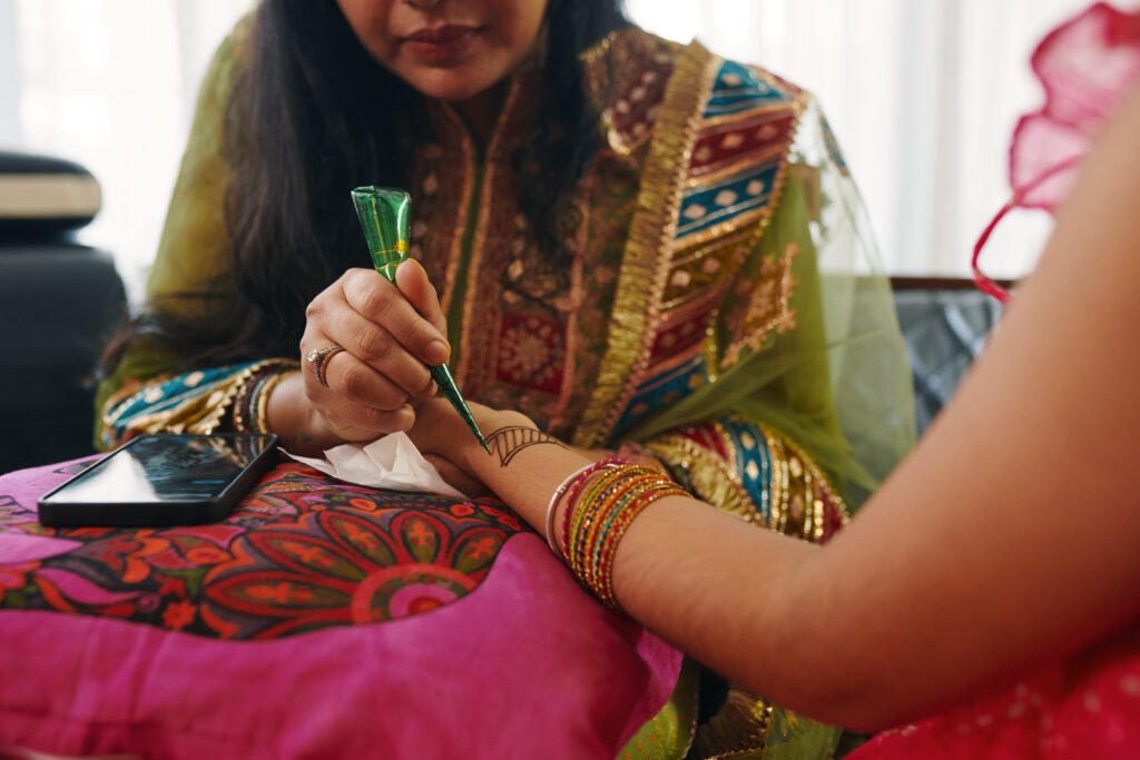 Mom Drawing Henna Patterns On Hand Of Her Daughter